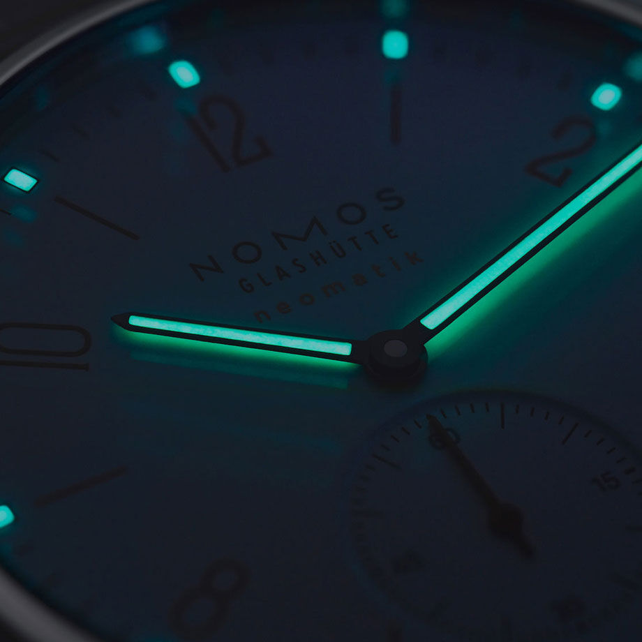 NOMOS Glashütte / Ahoi neomatik Sirenwhite 564 / AH130011SW2　564シグナルホワイトのアホイ・ネオマティックは20気圧防水で、画期的で精巧なネオマティックキャリバー、DUW 3001を搭載したスポーティな自動巻き時計。  ノモスが開発した同キャリバーは、わずか3.2ミリ－切手を9枚重ねただけの薄さで、極めてスリムな腕時計が出来上がりました。  光沢のある白い文字盤にクラシックな数字と秒針を繊細な赤と青が彩ります。 インデックス、針、分メモリのポイントにはスーパールミノバが塗布され暗闇での視認性を確保します。  ねじ込み式のリューズだけでなく、リューズガードを配することで水周りでも安心してお使いいただけます。 最大20気圧までの防水で、水泳、ヨット、サーフィン、ダイビングにぴったりです。  テキスタイルのストラップは頑丈でエレガント。 ノモス・グラスヒュッテのためにフランスでテーラーメイドされています。