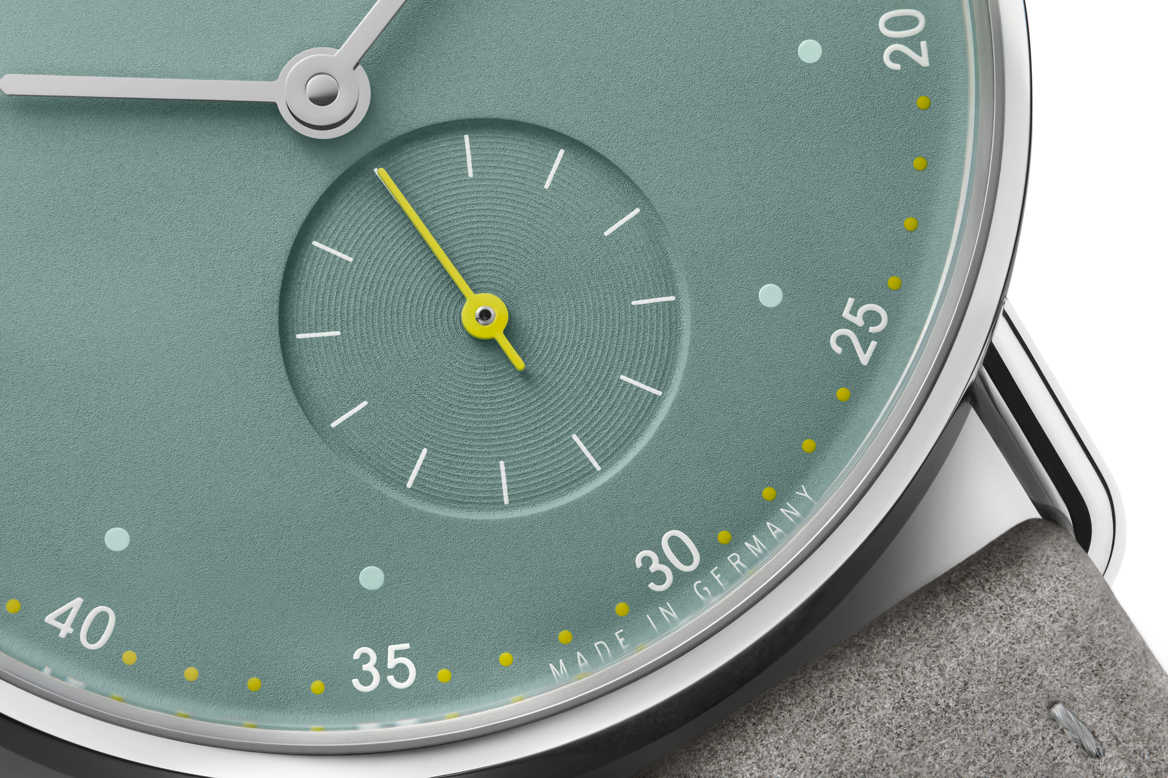 NOMOS Glashütte / METRO 33 / NM1124スタイリッシュなメトロの10周年に向けて、フェミニンなサイズ33のSSケースがファミリーに加わります。  大都会をイメージしたメトロ33は輝くガラス張りのビル（オールシルバー）・ブルックリンによくみられる赤煉瓦の建物（ミュートレッド）・公園や自由の女神の心豊かな緑（セージ）の3色です。  複雑なダブルカーブのサファイアクリスタルガラス、繊細なワイヤーラグ、また時計師が使う道具をモチーフにした特徴的なメトロリューズなど、すべてが非の打ちどころのないグラスヒュッテのクラフツマンシップと最高基準のデザインです。  時計のデザインを引き締めているのはライトグレーのヴィーガンベロアストラップ。スマートで遊び心があり、エネルギーに満ちている現代的なエレガンスを表現している3種類のメトロは、女性でだけでなくもちろんスレンダーな腕周りの男性にも似合います。
