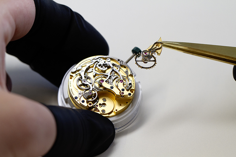 世界初のクロノグラフ「コンター・ドゥ・ティエルス」をモチーフに現代の技術を導入して開発されたルイ モネの腕時計クロノグラフ「1816」ムーブメントの組み立て。ゴールドカラーの地板とブリッジに鮮やかなコントラストをなす歯車やレバーに機械式時計ならではの魅力が溢れている。