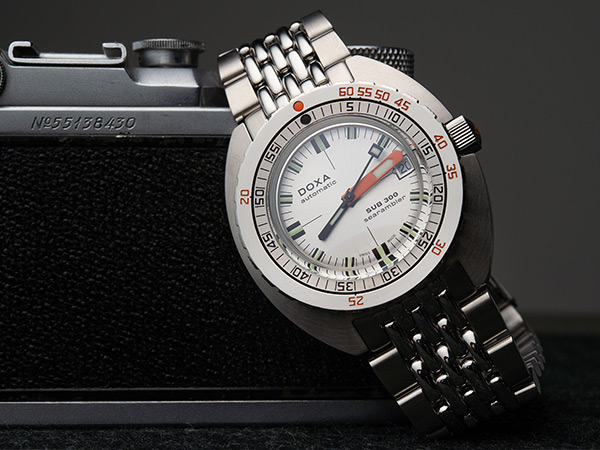 「ドクサ」のフラッグシップ・モデルである「DOXA SUB 300 Searambler」。1967年に発表されたヒストリカルなモデルを復活させたもので、30気圧（約300メートルの深度に相当）の防水性を備え、減圧停止なしで安全に浮上できる深度と潜水時間を計測できるデュアルスケールを備えた逆回転防止ベゼルが初めて搭載された