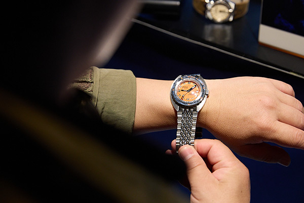 オレンジ・ダイアルの「DOXA SUB 300T Professional」を試着する来場者。1960～70年代にかけて大きなブームを巻き起こしたトノー・シェイプのケース・フォルムにビビッドなオレンジの文字盤が絶妙にマッチする。