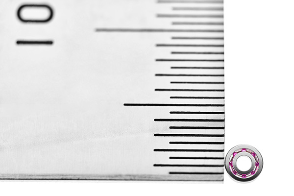 0.5mm刻みのスケールで計測した外形2.5mmのルビーボール・ボールベアリング。ミネベアミツミ特注品。そこに8個のルビーボールが収められている。